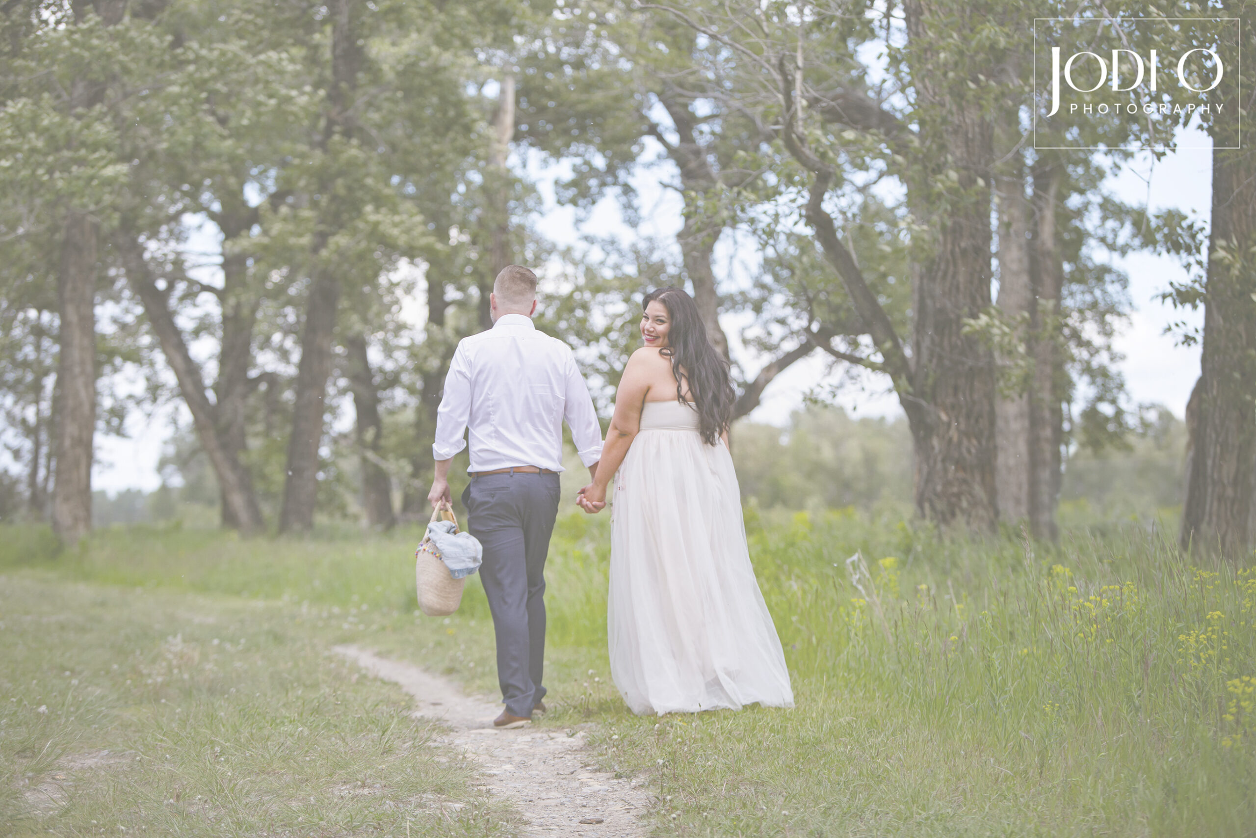 Couple walking away and bride peeking over shoulder with a smile at their wedding in Calgary